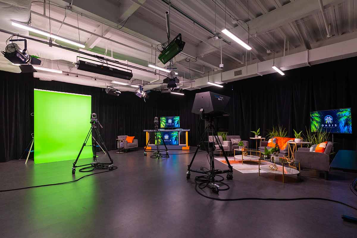 Full TV studio, including green screen, news, and podcast/interview pannels